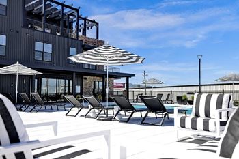 Pool deck with seating and umbrellas at artisan flats apartments in birmingham, al